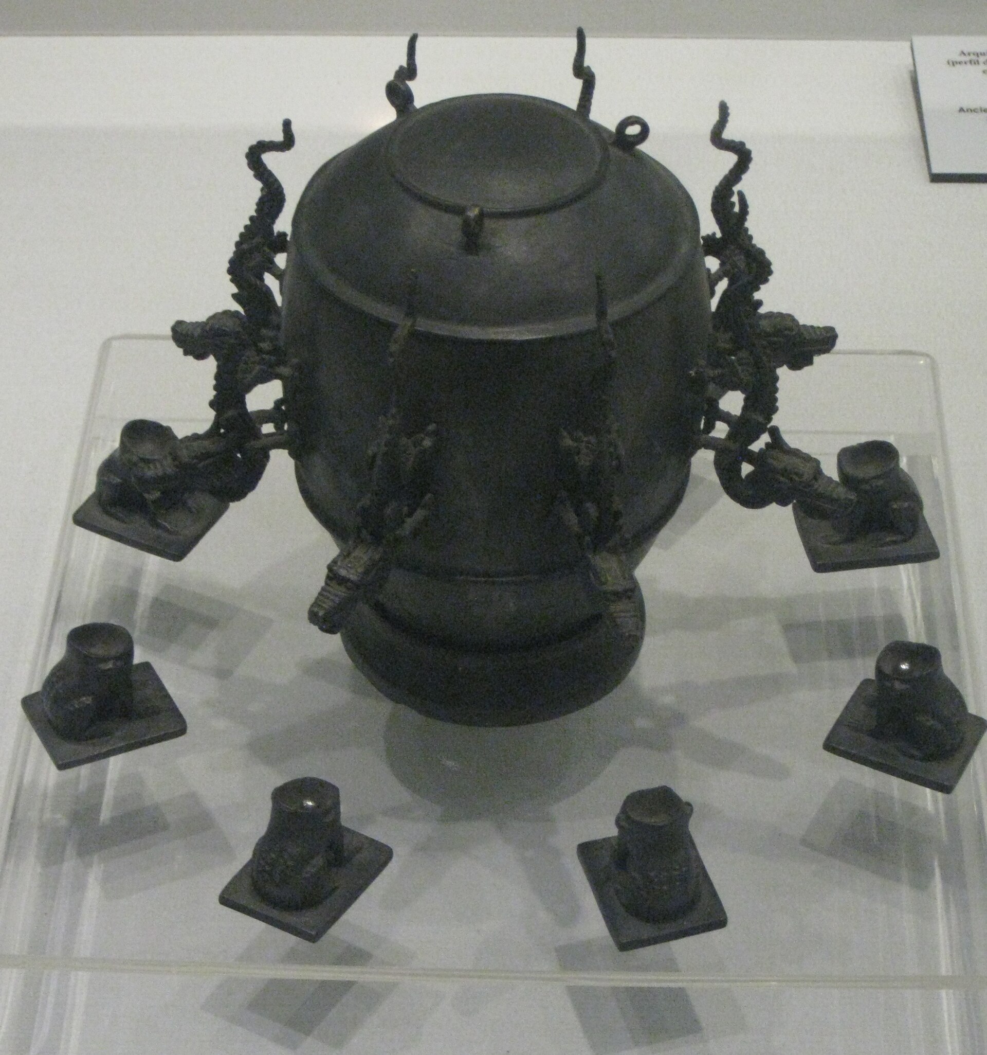 A modern replica of Zhang Heng's seismoscope on display at the Museum of Macau: a bronze vessel with dragon heads around the rim and toads at the base
